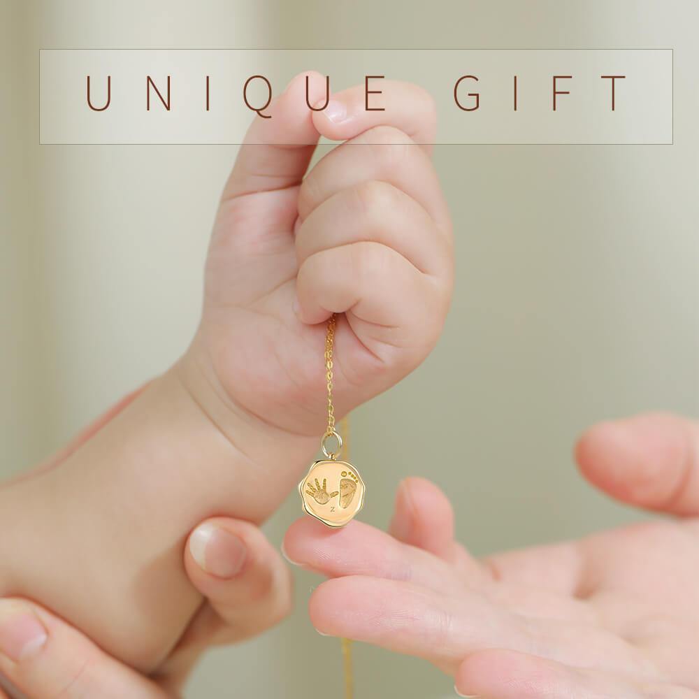 Baby holding 18k gold custom footprint necklace